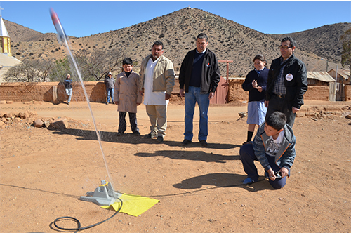 Picture of a student and school principal from the town of Almirante Latorre enjoy the excitement of their first rocket launching.