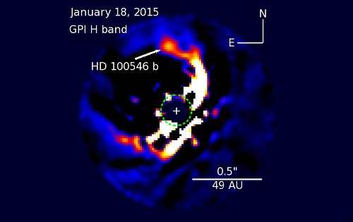 Image of a star system called HD 100546. A green shaded area shows the region where the instrument blocks out the light of the central star. A bright point of light, HD 100546 b, is visible near the edge of the blocked out region.