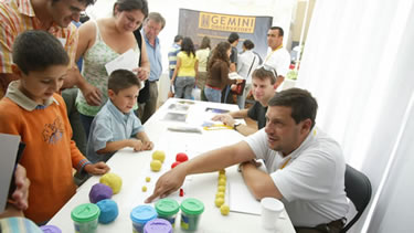 Picture of Rodrigo Carrasco and James Turner interacting with children at the "Ask the Astronomer" booth.