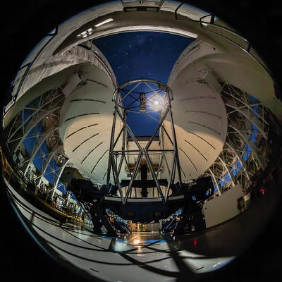 Gemini South telescope inside with a moonlit dome at night.