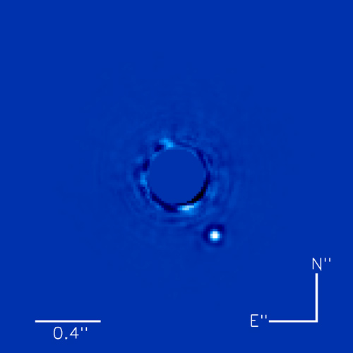 This image shows a directly captured image of a planet, Beta Pictoris b, orbiting the star Beta Pictoris (which is hidden by a mask).